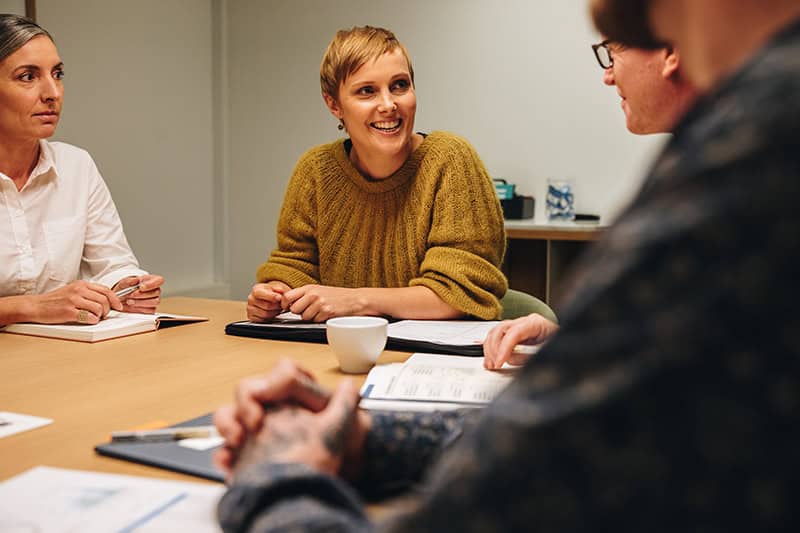 Glade kollegaer i trivsel grundet god arbejdsmiljø ledelse i hverdagen.