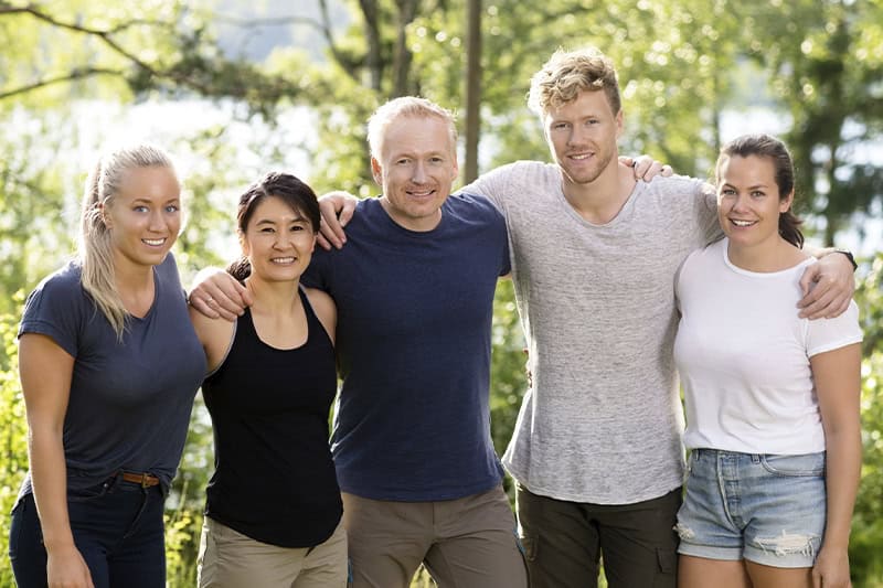 Glade kollegaer i omfavnelse til sjov teambuilding i naturen med små team-øvelser.