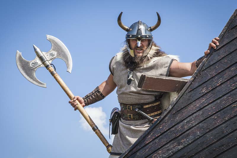 Mand med skæg, hjelm og økse er udklædt som viking til anderledes teambuilding