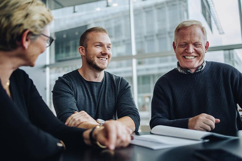 Leder sidder sammen med sine medarbejdere og løfter kommunikationen i teamet.