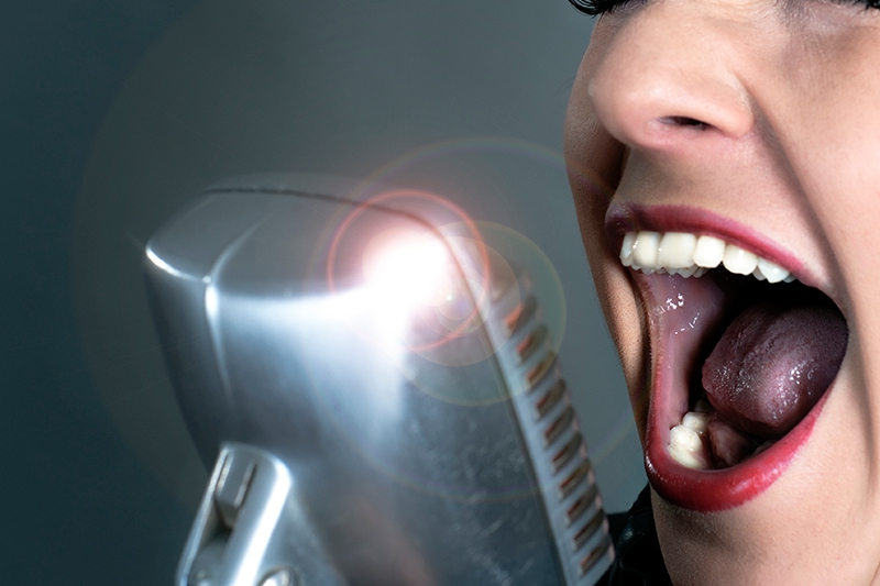 Kvinde synger til teambuilding musik med sang, dans og fællesskab.