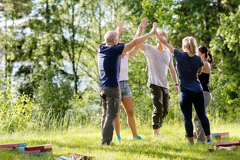 Glade mennesker samlet til en sjov teamdag i den fynske natur med sjove øvelser.